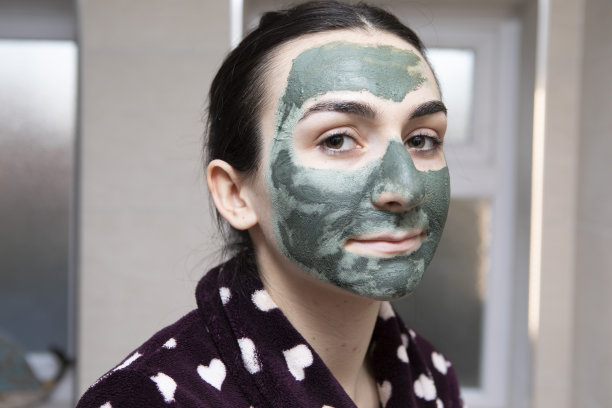 一个年轻女子的肖像与绿色的面具看着相机图片下载