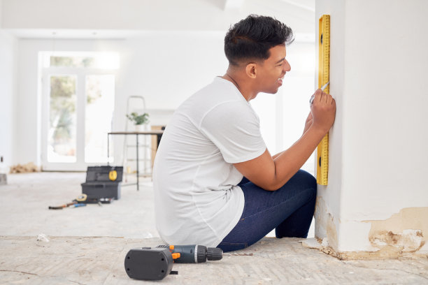 一名男子在翻修房子时使用水平仪的照片图片下载