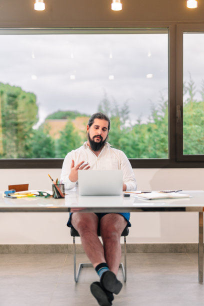 一名年轻的企业家正在开工作视频会议，却没穿裤子。图片下载