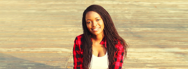 快乐微笑的年轻非洲妇女在城市随意的肖像图片下载