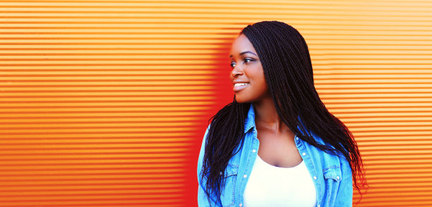 快乐的年轻微笑的非洲妇女在生动的背景随意的肖像图片下载