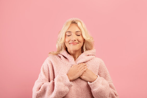 感恩的概念。感恩的女士，手掌放在胸前，闭上眼睛微笑，表示感谢图片下载