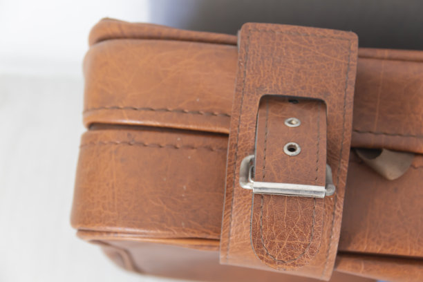 白色墙壁旁的棕色复古手提箱上有个古董钩子。图片下载