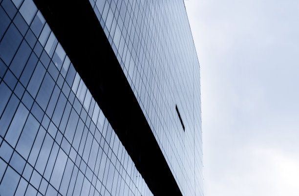 摩天大楼的玻璃墙对着天空。都市主义的概念。图片下载