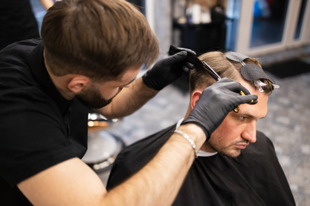 师傅在理发店为男士理发，理发师为年轻人理发图片下载