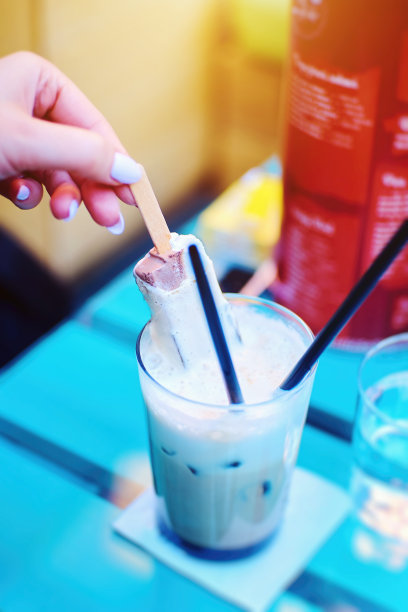 女性手握冰咖啡里的冰淇淋图片下载