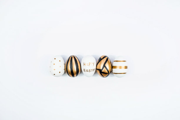 金色，黑色，白色鸡蛋在一个白色孤立的背景。几何学。最小的概念。前视图。复活节卡片上有副本的文字。图片下载