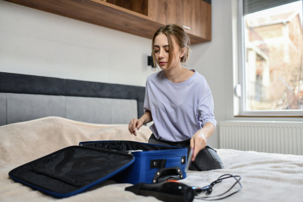 在打包旅行时，专注的女性在行李中为扇子腾出空间图片下载