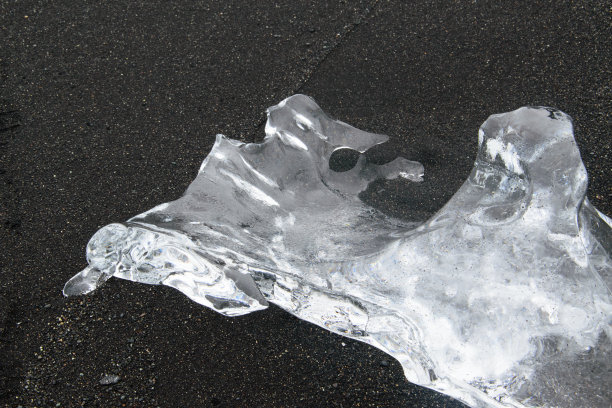 冰山、冰原和冰山泻湖上的冰块Jökulsárlón。泻湖穿过一条短水道流入大西洋，在黑色的沙滩上留下了大块的冰。图片下载