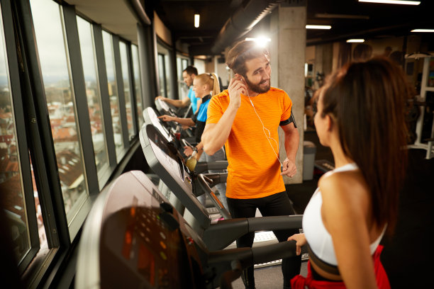 年轻人在跑步机上锻炼和交流之后休息图片下载