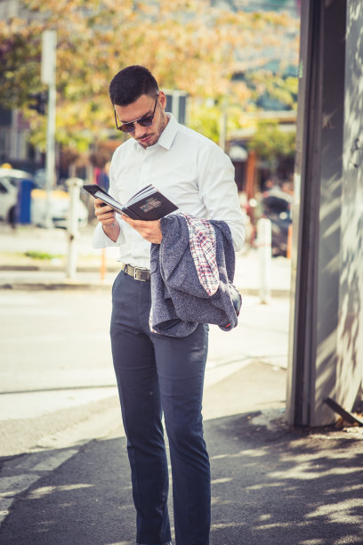 一位时髦的商人正在市中心看书图片下载