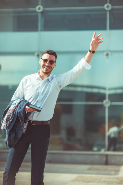 城市里时髦的商人，微笑着向别人招手图片下载