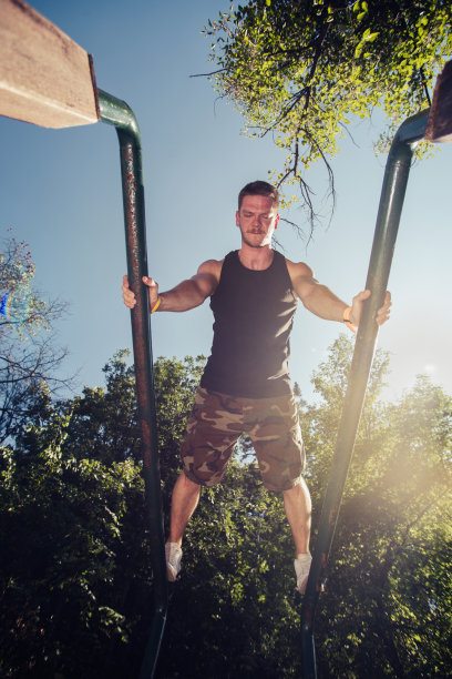 男子在户外双杠上锻炼图片下载