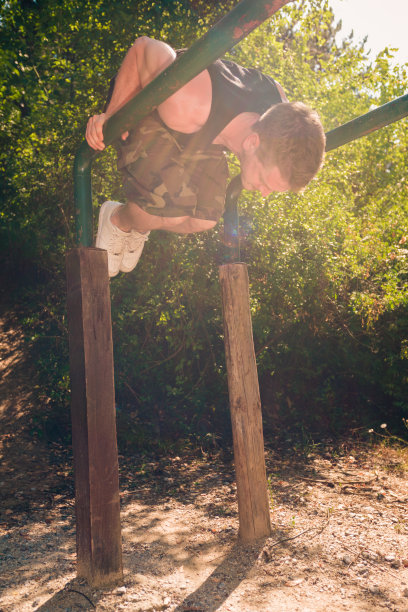 男子在户外双杠上锻炼图片下载