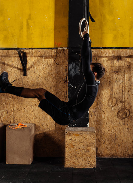 年轻健美的男子在跳体操吊环图片下载