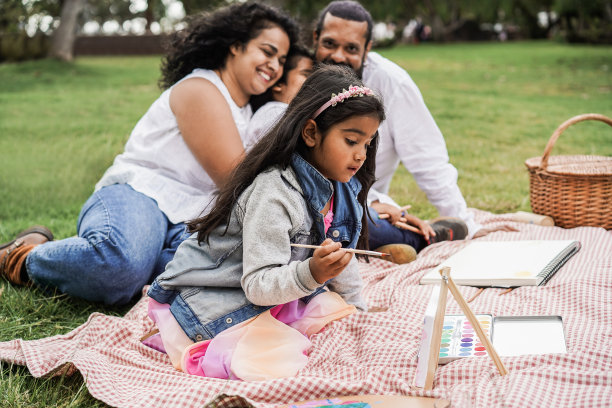 快乐的印度家庭与孩子们在城市公园画画-关注女孩的脸图片下载