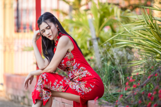 肖像美丽的微笑亚洲年轻女子穿着红色的中国传统旗袍装饰中国春节在泰国的中国神社图片下载