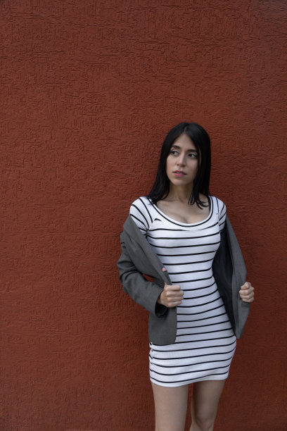 身材苗条的年轻拉丁女子留着长长的黑发，美丽又时尚的女模特穿着休闲夹克和连衣裙图片下载