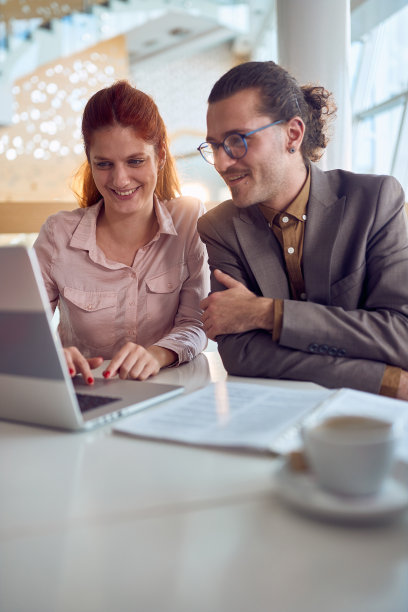 年轻的同事们坐在桌前，一起看着笔记本电脑上的内容。公司业务、人图片下载