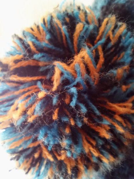 一个橙色和蓝色婴儿帽娃娃的微距摄影图片下载