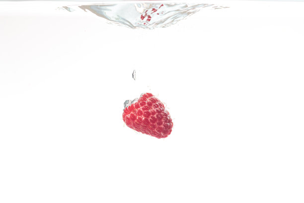 一个覆盆子溅在白色的水里图片下载