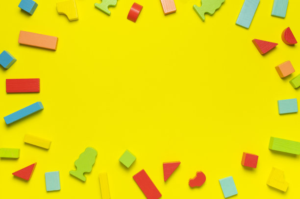 多色的儿童构造器由天然木材在明亮的黄色背景平躺顶视图。用于建筑的彩色儿童砖。构建块的背景。开发玩具、游戏图片下载