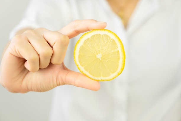 厨师正在展示切好的柠檬片，并把它们放在一个木制的切菜板上。图片下载