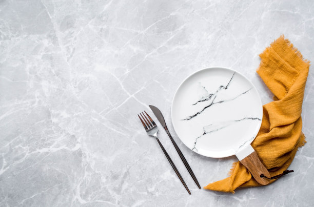 横幅。一个空的陶瓷大理石盘子，木柄，叉子，刀子和毛巾，背景是灰色的混凝土桌子。空间的文本。咖啡馆和餐厅的菜单概念。图片下载