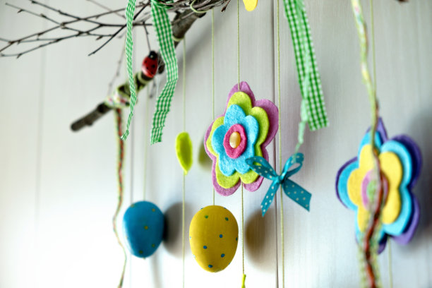 墙上装饰着喜庆的复活节树枝、毡花和蝴蝶、五颜六色的彩蛋。复活节快乐的概念。图片下载