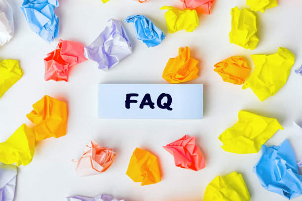 蓝色的便利贴与文本FAQ和一些彩色的揉皱的纸球周围的白色背景。收集关于任何主题的常见问题和答案。静物画图片下载