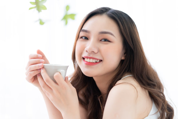 早上在家里喝茶的年轻漂亮的亚洲女人的形象图片下载
