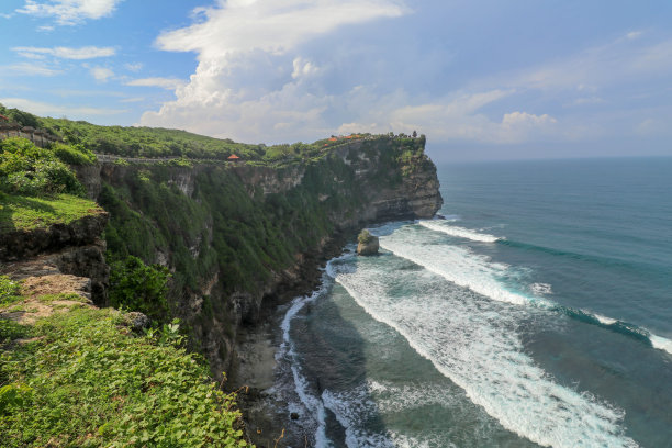全景海景，海岸，悬崖。被淹没的场景鲜花和绿色覆盖的垂直悬崖在印度洋上。巴厘岛南部，Pura Luhur Uluwatu寺庙。印度尼西亚。图片下载