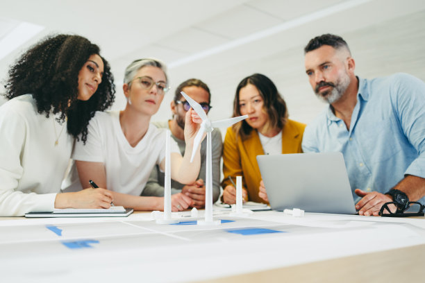 多文化设计师在一个风力涡轮机项目上工作图片下载