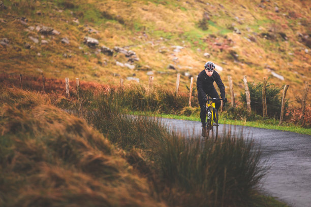 年轻的白人骑自行车的人在山上骑自行车。图片下载