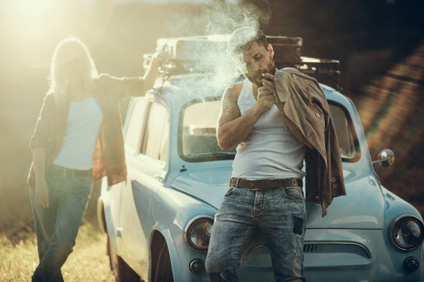 一对年轻夫妇开着一辆蓝色老爷车旅行图片下载