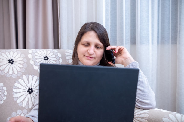 一位年轻女子在酒店房间里工作图片下载