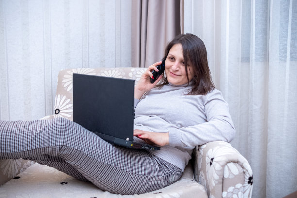 一位年轻女子在酒店房间里工作图片下载