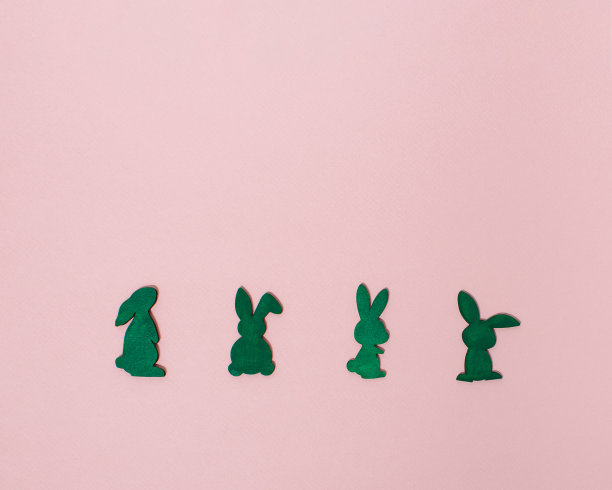 兔子水平排列在淡粉色背景与复制空间。最小的复活节概念与兔子。平坦的复活节季节。图片下载