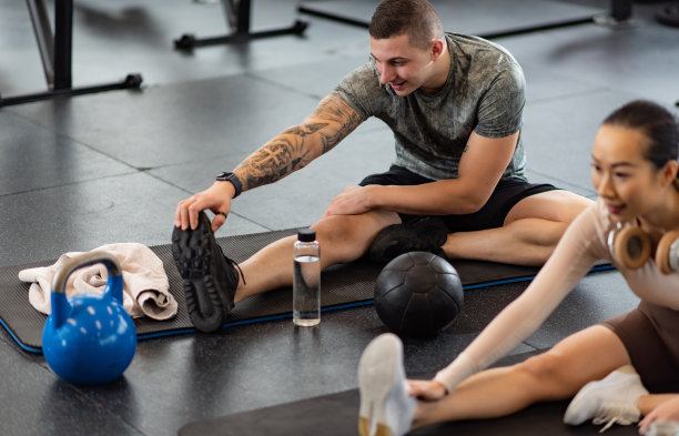 一对情侣在健身房做热身运动图片下载