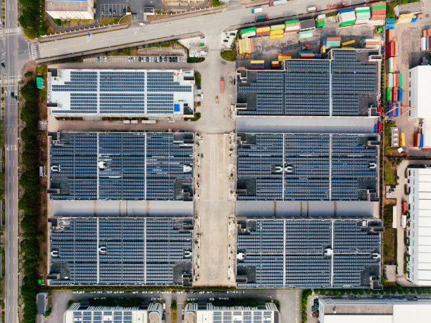 工厂屋顶上太阳能电池板的鸟瞰图。蓝色闪亮太阳能光伏板系统产品。图片下载