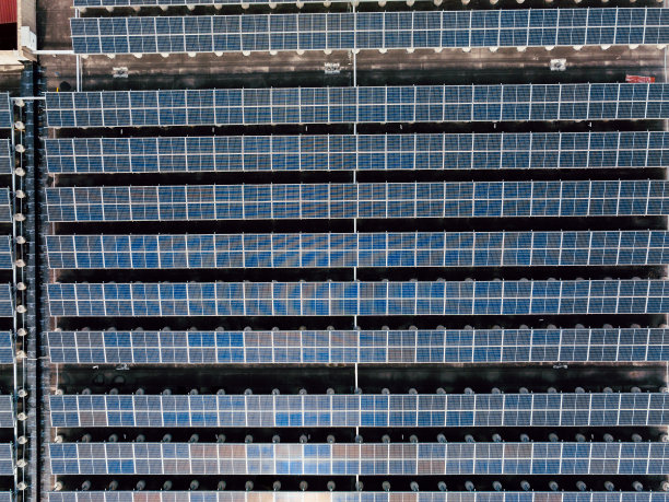 工厂屋顶上太阳能电池板的鸟瞰图。蓝色闪亮太阳能光伏板系统产品。图片下载