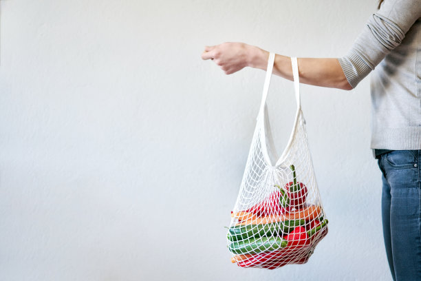 妇女手中拿着可重复使用的购物袋。图片下载