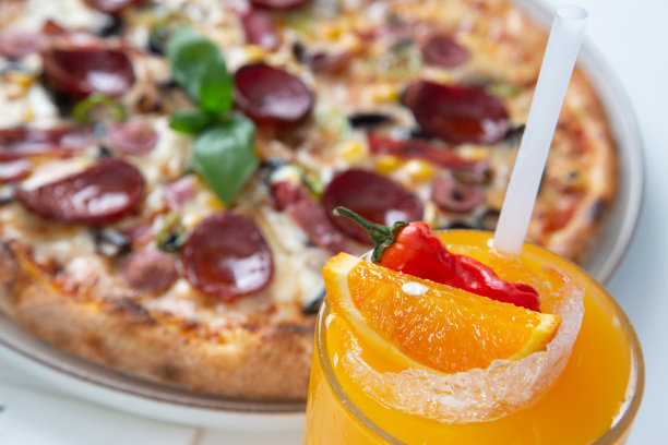 一杯橙汁配意大利辣香肠和蘑菇披萨图片下载