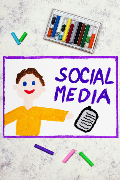 彩图:微笑的男孩拿着手机和文字社交媒体图片下载