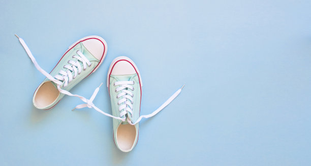 柔和的蓝绿色的女性运动鞋在蓝色的背景。平躺，顶视图最小的背景。时尚博客或杂志概念图片下载