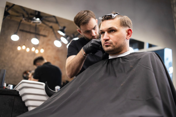 师傅在理发店为男士理发，理发师为年轻人理发图片下载