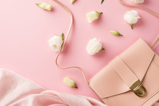 俯视图照片的妇女的一天组成粉红色皮革手袋软纺织品和白色草原龙胆草花蕾在孤立的淡粉色背景copyspace图片下载
