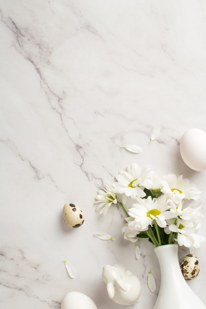 顶部垂直视图照片的菊花花瓶，几个鸡蛋和陶瓷兔子在孤立的大理石背景copyspace图片下载