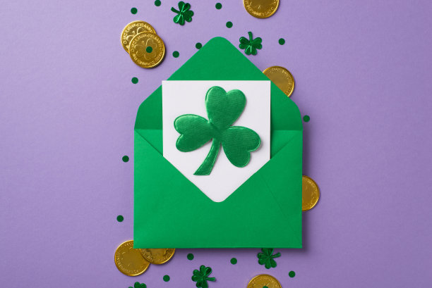 俯视图照片的绿色信封与白色的卡片里面和漂亮的三叶草在它金色硬币纸屑的形状三叶草和点在孤立的紫色背景copyspace中间图片下载