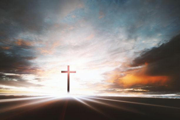 耶稣基督的圣十字架照耀着天空、云朵和明亮的光束图片下载